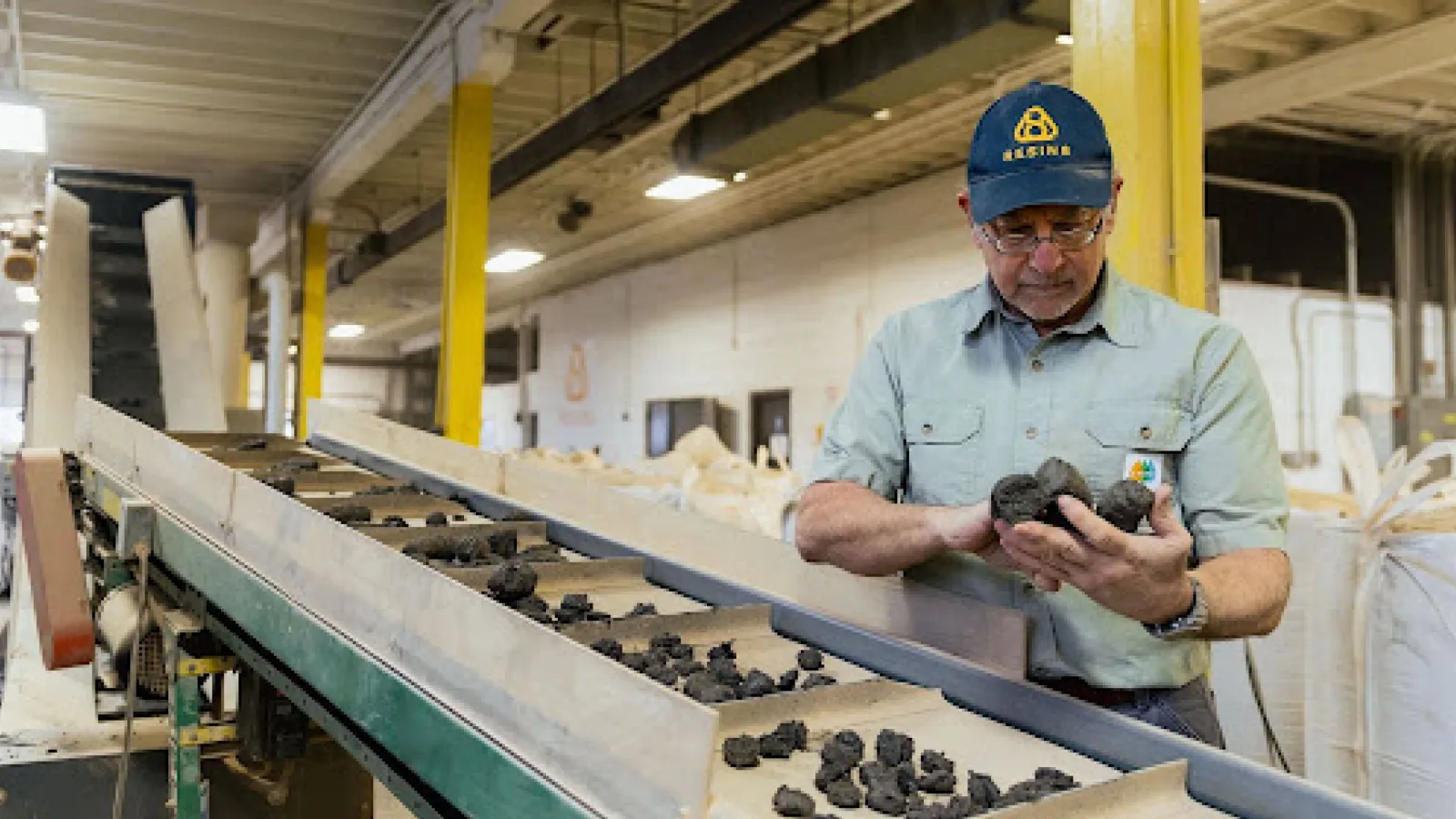 A worker inspecting recycled plastic material at the CRDC Malta facility