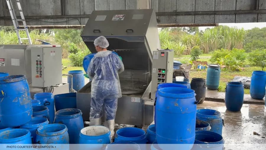 A CompostaMais worker cleaning food-waste collection drums