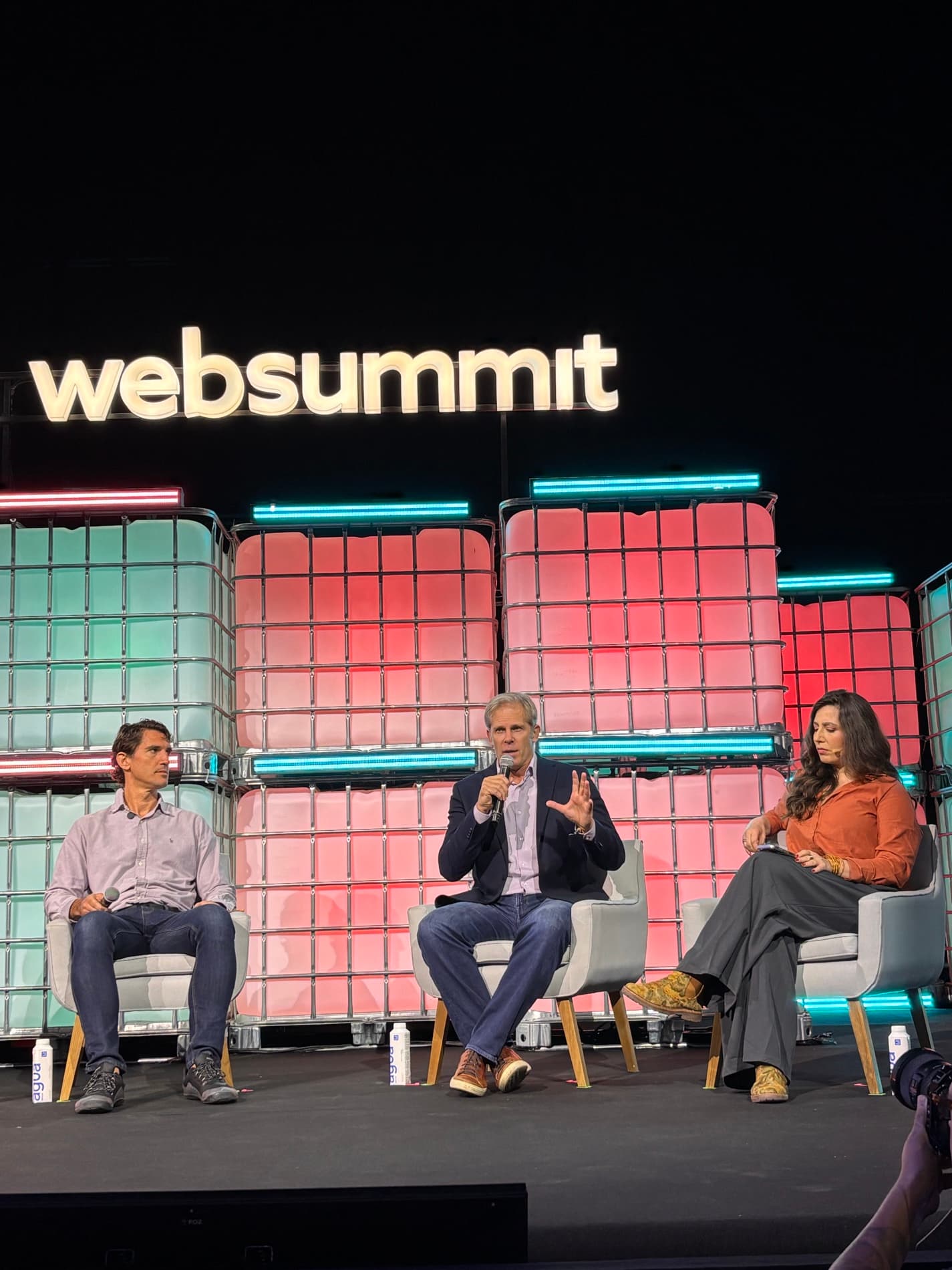 Ian McKee speaking on a panel at Web Summit Rio, microphone in hand