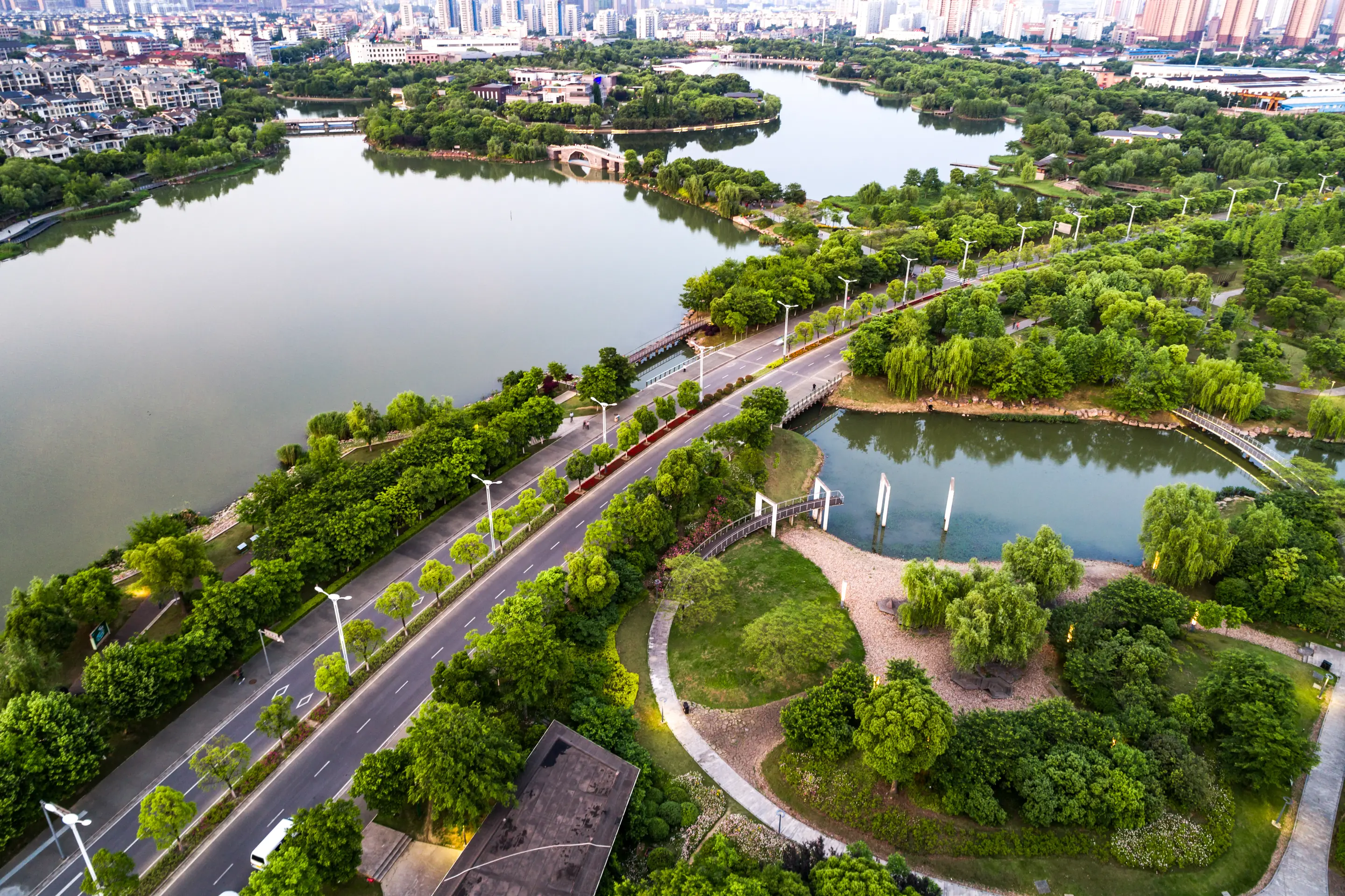 Aerial photograph: a city interwoven with lakes, parks and dense tree canopy, with the skyline on the horizon.